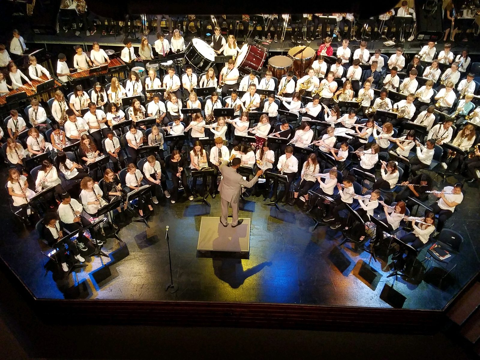 Conducting a full concert band ensemble on stage